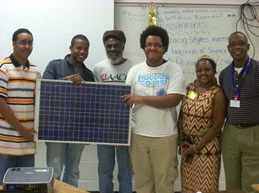 Funded project recipients hold a solar panel picture.
